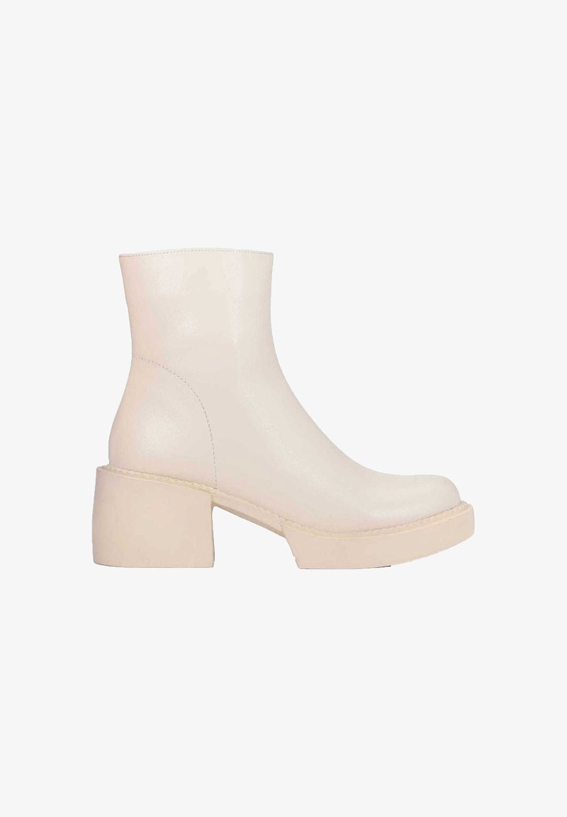 Bottine couleur crème avec talon bloc épais et finition en cuir lisse, vue de côté sur fond blanc.