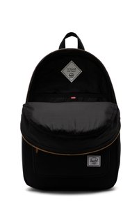 Svart ryggsäck med en rundad topp, som har en guldfärgad dragkedja, inuti randigt foder och en diamantmärkespatch på framfickan.