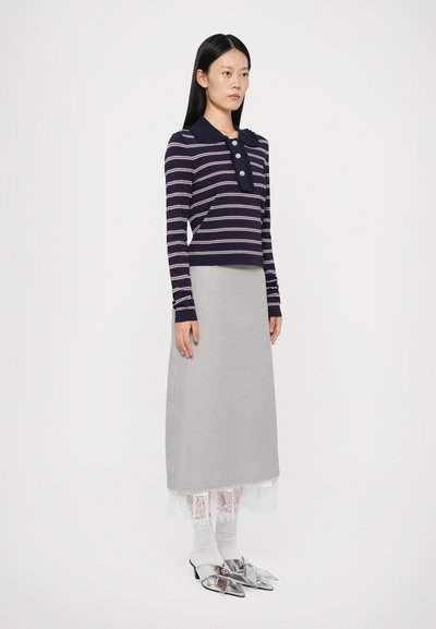 Navy- und rosa gestreiftes Langarmoberteil mit Rüschensaum, kombiniert mit einem grauen Rock mit Spitzenbesatz und silbernen Mules.
