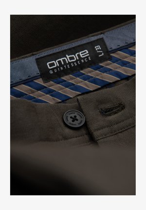 Ombre značková tmavě hnědá tkanina s černým knoflíkem, na vnitřní straně s pruhovaným modro-beige akcentem.