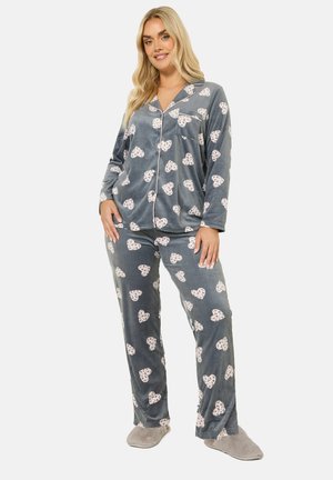 Grijs fluwelen pyjamapak met witte hartpatronen. De top heeft een knoopsluiting met een borstzak, en de broek heeft een losvallende pasvorm.