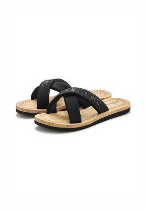Black flip-flops with cross-over straps in a smooth material. Textured cork-like footbed with black outsole. Minimalist design, no additional decor.