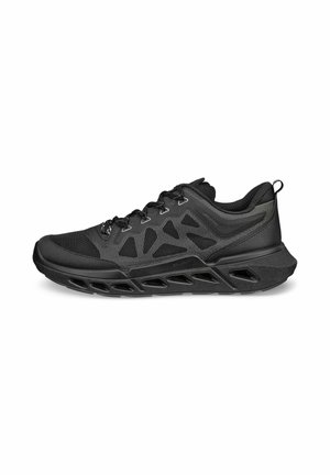 Chaussure de sport noire avec une tige en mesh, un design texturé, une fermeture à lacets et une semelle surdimensionnée amortie avec des découpes pour plus de flexibilité.