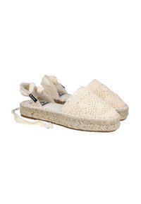 Espadrilles de ganchillo de encaje en color blanco roto con suelas de yute trenzado. Presentan cintas para atar en el tobillo y una punta redondeada. Upper texturizado con diseño recortado.