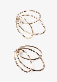 Gold-tone metal earrings featuring intertwined loops, showcasing a smooth texture with a polished finish and an abstract design.