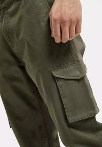 Oliwkowe spodnie cargo o teksturowanym wykończeniu, z dużą kieszenią boczną i przeszyciami wzdłuż szwów.