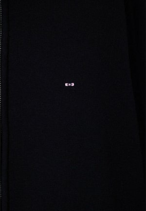 Tissu tricoté noir avec un petit logo rose brodé, centré, représentant deux yeux stylisés.