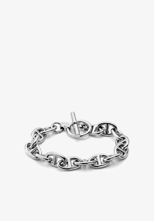 Sølv kjedearmbånd med avlange, sammenkoblede ovale lenker og en rund vippe lås, vist på hvit bakgrunn.