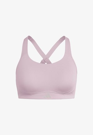Brassière de sport rose clair avec une finition lisse, des bretelles larges et un dos croisé. Présente un marquage discret en bas.