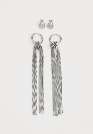 Silver earrings set, featuring circular studs and large hoop earrings with cascading metallic strands and knot details.