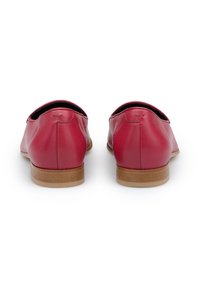 Czerwone skórzane buty wsuwane z niskim obcasem, gładką fakturą, okrągłym kształtem i kontrastującymi drewnianymi podeszwami. Brak widocznych elementów metalowych i wzorów.