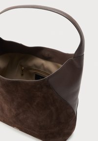 Bruine leren en suède shopper met een gladde textuur, voorzien van een enkele schouderriem en een binnenvak met rits.
