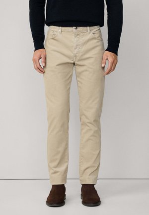 Beige Baumwoll-Chinos mit geradem Schnitt. Merkmale sind Fronttaschen, ein Knopfverschluss und Gürtelschlaufen. Strukturierte Stoffoberfläche.