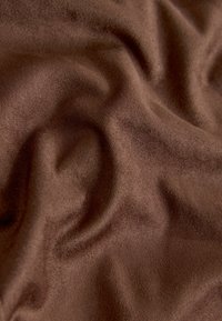 Brauner Stoff mit weicher, glatter Textur, zeigt sanfte Falten und eine satte, gleichmäßige Farbe ohne Muster oder Verzierungen.