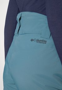 Columbia Titanium kratke hlače; svijetloplava tkanina s glatkom teksturom, s logotipom i ravnim dizajnom pojas. 