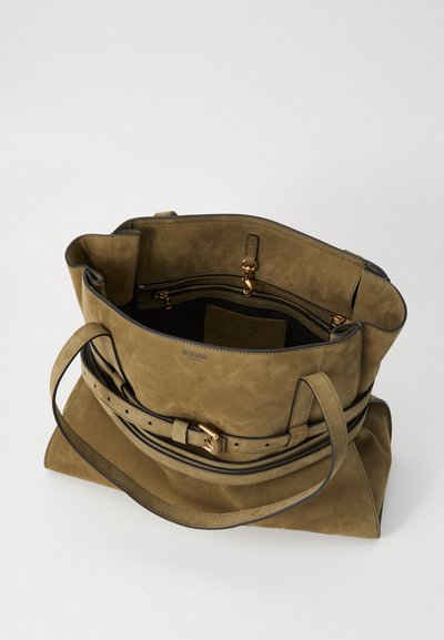 Borsa tote in suede verde oliva con dettaglio a cintura, scomparto interno con zip e una texture morbida. Presenta accessori in hardware color oro.