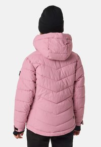 Lyserød isoleret jakke med hætte, dekoreret med chevron-syning, elastiske manchetter og en sort strikket hue. Sorte accenter nær manchetterne.