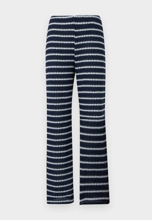 Πλεκτό παντελόνι σε ναυτικό μπλε και λευκές ριγέ ζιγκ ζαγκ με ευθεία κοπή στα πόδια, πάνω σε ουδέτερο φόντο.