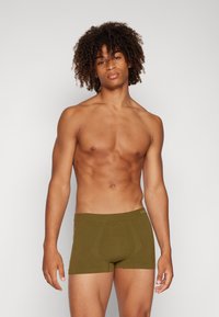 Grüne, enganliegende Boxer-Briefs mit glatter Oberfläche, elastischem Bund und Vorderpouch-Design. Hergestellt aus weichem, dehnbarem Material.