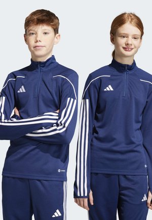 Vestes de sport bleu marine avec un design à demi-glissière, des bandes blanches sur les manches et des accents texturés sur les épaules. Fabriquées en matériau respirant.