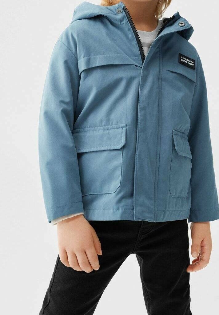 Vaaleansininen vettä hylkivä takki hupulla, vetoketjukiinnitys, kaksi etutaskua ja pieni logopatchi rinnassa. Rakennekangas.