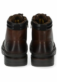 Bruine leren enkelboots met een zwarte synthetische kraag, ritssluitingen en een getextureerde rubberen zool. Gevoerd met bruine bont voor isolatie.