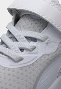 Λευκό αθλητικό παπούτσι με άνω μέρος από πλέγμα, υφασμάτινα κορδόνια με υφή, ρυθμιζόμενο λουράκι και λαστιχένια σόλα. Χαρακτηρίζεται από οπές αερισμού και μαξιλαρωτή στήριξη.