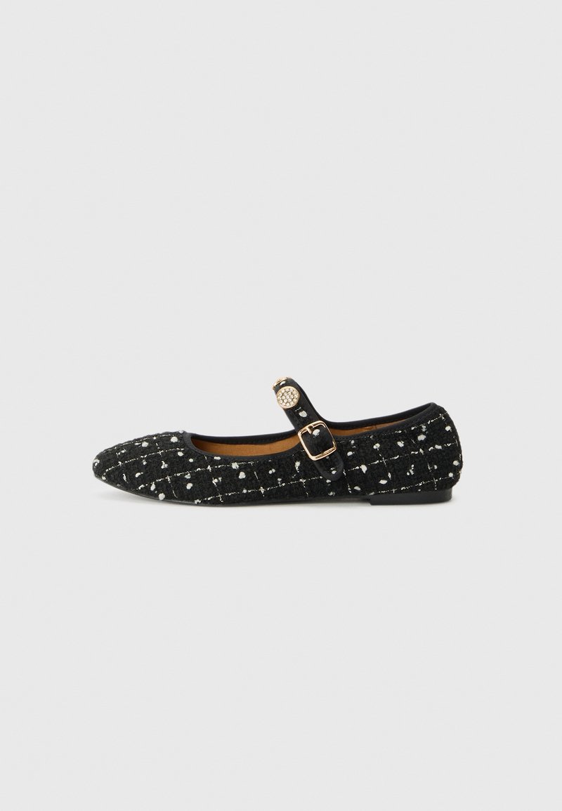 Chaussure plate Mary Jane noire avec motif blanc moucheté, boucle dorée et bouton décoratif rond doré sur la bride latérale.