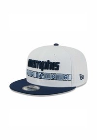 Weißes Snapback-Cap mit navyfarbenem Schirm, mit erhabenen "memphis"-Schriftzug und gemustertem Band mit geometrischen Designs in Blau und Weiß.