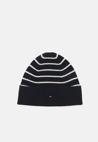 Strikket lue i mørk marineblå med hvite horisontale striper. Ribbete tekstur, brettet mansjett og en liten logo detalj foran.