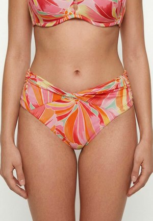 Kobieta nosząca bikini z wysokim stanem oraz top z abstrakcyjnym, kwiatowym wzorem w kolorach różowym, pomarańczowym, żółtym i zielonym na jednolitym tle.