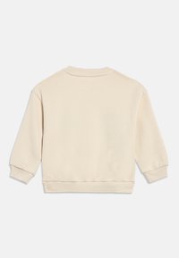 Krēmkrāsas garroku krekls ar apaļu kakla izgriezumu, ar ribotām aprocēm un apakšu, attēlots no muguras uz vienkārša balta fona.