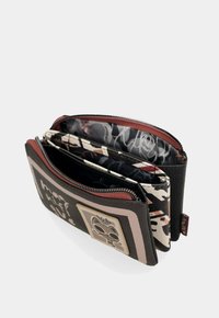 Portafoglio pieghevole in pelle nera con dettagli beige e bordeaux. L'interno presenta fodere a motivo e più scomparti con chiusure a zip.