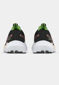 Ténis de corrida pretos com parte superior texturada, detalhes em verde neon e sola branca acolchoada com padrões de tração.