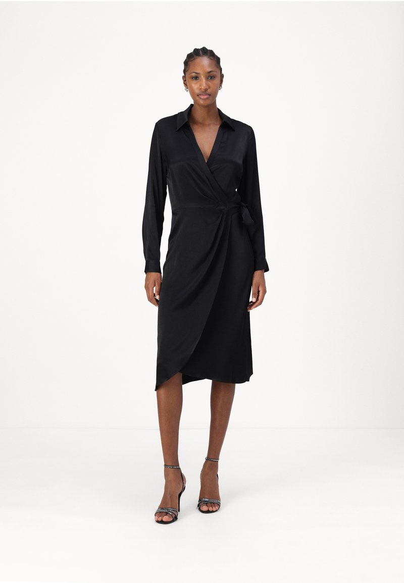 Black satin wrap dress with long sleeves, V-neck, and tie detail at the waist. Features a knee-length hem and smooth texture.