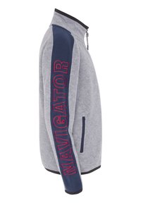 Chaqueta de forro polar gris con un cuello alto, panel lateral azul marino que presenta "NAVIGATOR" en rojo, bolsillos con cremallera y ribetes negros en contraste.