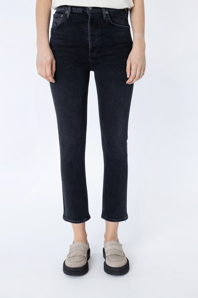 Donkerblauwe hoogwaist jeans met een slim fit, met opgerolde zoom. Gecombineerd met lichtgrijze suede instappers met franjes.