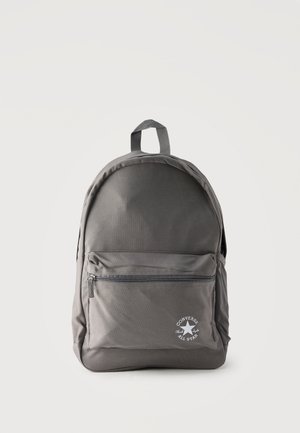 Šedý batoh Converse All Star s predným vreckom na zips a horným úchytom na prenášanie na jednoduchom svetlom pozadí.