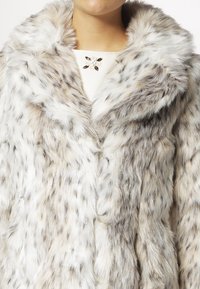 Faux fur coat with a soft texture, featuring a mix of white and gray strands, and a wide collar. Button closure and subtle animal pattern.