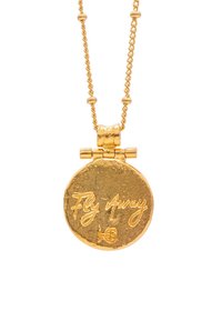 Collana con pendente in oro che presenta un ciondolo rotondo con una finitura testurizzata e il testo inciso "Vola via". Catena linkata con accenti di perline.