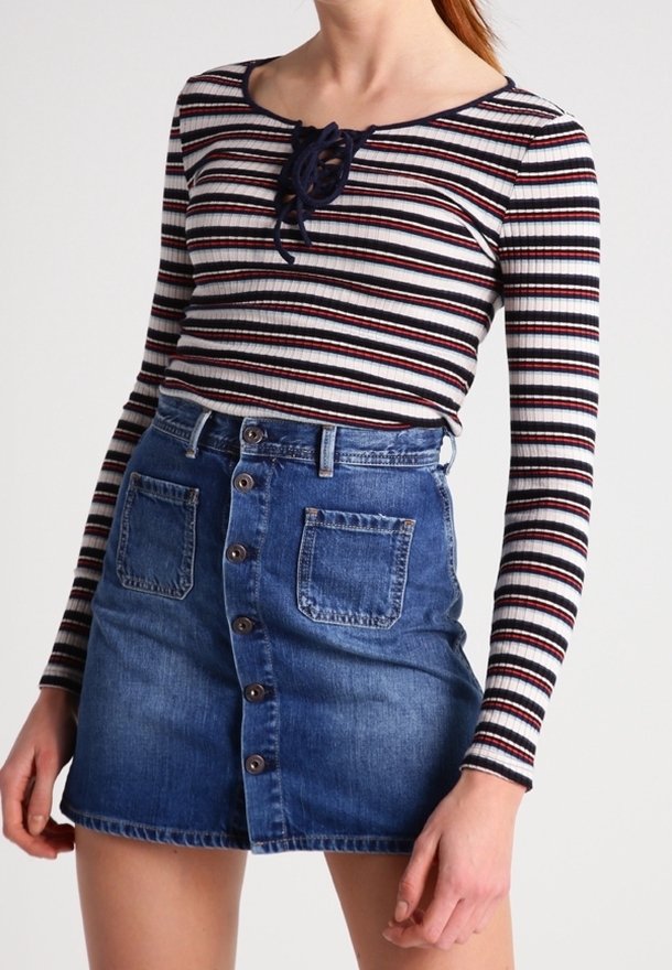 Randig långärmad topp med snörning i halsen, matchad med en jeanskjol med knappstängning fram och två framfickor.