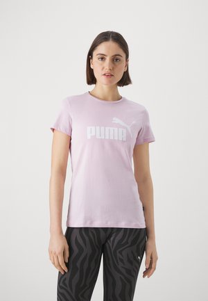 Camiseta de algodón de color rosa claro con mangas cortas, que presenta un gran logo blanco de "PUMA". Combinada con leggings negros con un patrón de rayas de cebra.