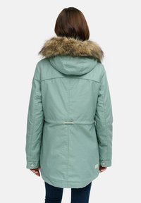 Jasnozielona parka z kołnierzem z sztucznego futra, regulowanym w pasie, kapturem ze sznurkiem i mankietami na napy. Wykonana z trwałego, teksturowanego materiału.
