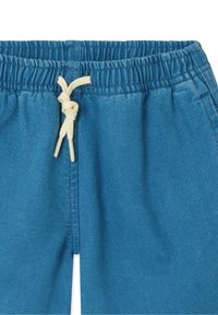 Pantalon à taille élastique bleue avec cordon de serrage. Présente une texture de tissu lisse et des coutures latérales. Design minimaliste sans ornements supplémentaires.