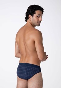 Boxer aderenti blu navy con un motivo a griglia in tonalità più chiare. Realizzati in un tessuto morbido, con una vita a contrasto e una vestibilità aderente.