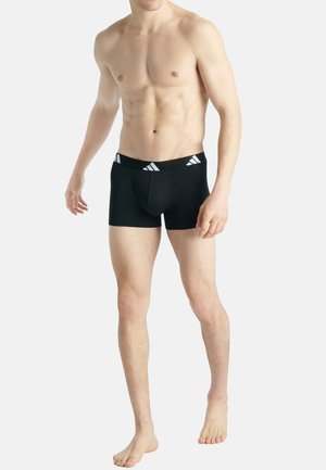Zwarte boxershorts gemaakt van rekbaar materiaal, met een eenvoudig ontwerp en een brede tailleband met drie witte strepen.