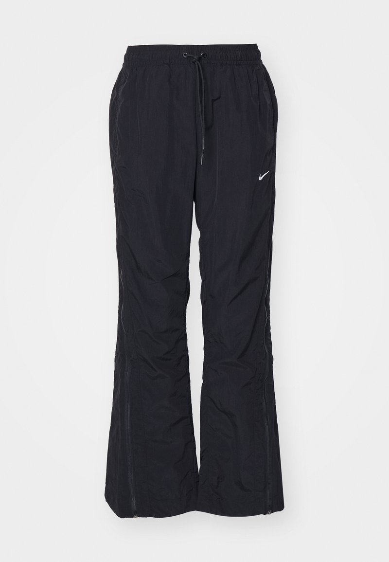 Pantalon en nylon noir avec une taille à cordon, des ouvertures latérales zippées et un petit logo Nike blanc sur la cuisse gauche.