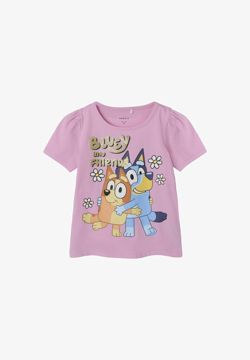 Jasnoróżowa bawełniana koszulka z grafiką przedstawiającą dwa rysunkowe psy z detalem kwiatowym oraz napisem "Bluey i przyjaciele" w błyszczącym złotym kolorze.
