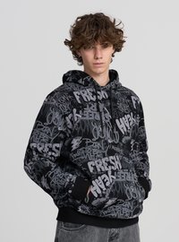 Czarna bluza z kapturem ozdobiona mieszanką szarych tekstów i grafik w stylu graffiti. Kaptur ze sznurkiem, ściągacze na rękawach i kieszeń z przodu. Miękka tekstura materiału.