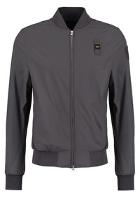 Gray bomber jacket with a zip closure, ribbed cuffs and hem, and two front pockets. Features a badge on the left chest. Smooth texture.